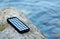 Portable powered solar usb located on a stone on the beach. Alternative energy. Eco