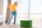 A portable smart green speaker plays music. In the background, a woman dances in a blur. Copy space. The concept of modern gadgets