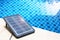 Portable solar cell panel on clear swimming pool background, clean energy concept