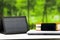 Portable solar charger sitting on white desk surface connected to tablet, modern technology concept, window garden