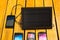 Portable solar charger sitting on wooden surface next to four mobile phones, as seen from above, modern green technology