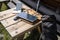 Portable Solar Panel Charging Mobile Device on Rustic Table, Backpack, Stunning Mountain View, AI Generative