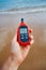 Portable thermometer in hand measuring outdoor air temperature and humidity