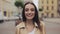 Portait of attractive young girl wearing trench looking happy smiling and laughing standing at city background close up.