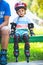 Portait of cute baby boy with inline skates sitting on bench.