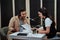 Portait of two radio hosts, man and woman talking with each other, reading a script while getting ready for a live show