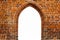 Portal door arch way window frame filled with white in the center of ancient red orange brick wall