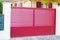 Portal steel big red metal gate fence on modern house street