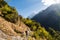 A porter with loads walking a scenic trail towards Mount Machapuchare