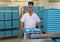 Porter With Plastic Trays In Hospital Kitchen