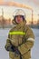 Portert Firefighter. A white man in overalls and a helmet is standing outdoors in the winter and looking directly at the camera