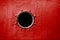 Porthole on red wall of old ship