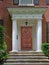 Portico entrance of brick house with large white columns