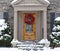 Portico entrance of house with snow covered bushes