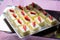 Portion biscuit cakes with buttercream decorated with fresh strawberries close-up. Sweets at festive banquet