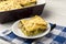 Portion of casserole with spinach, chicken and potatoes on the wooden background.