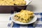 Portion of casserole with spinach, chicken and potatoes on the wooden background.