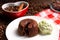 A portion of chocolate fondant with a scoop of pistachio ice cream on a plate.