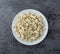 Portion of crumbled blue cheese on a white plate atop a gray background