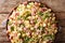 Portion of Ditalini pasta with green peas, ham and cheese closeup on a plate. horizontal top view