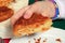 Portion of french galette des Rois in a child`s hand above a plate and crumbs