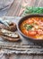 Portion of green lentil tomato soup with toasts