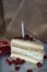 Portion homemade cream cake with candle and pomegranate seeds and chocolate spread