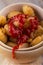 Portion of homemade gnocchi in yellow bowl with ketchup