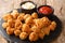 Portion of homemade snack Chicken popcorn with two sauces close-up on a slate board. horizontal