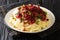 Portion of homemade venison with mashed potatoes and lingonberry sauce close-up in a plate. horizontal