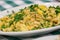 Portion of manioc farofa with eggs, typical Brazilian dish called farofa on green and white checkered tablecloth