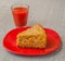 Portion of oat flour cake and glass of tomato juice