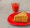 Portion of oat flour cake and glass of tomato juice