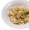 Portion of pelmeni with greenery on white plate