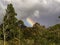 A portion of rainbow appears over the Andean forest