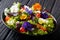 Portion of salad with edible flowers with fresh lettuce, spinach