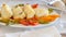 Portion slices of fried cod with slices of sweet bell pepper on the white dish, prepared for eating. Meditarranean healthy food