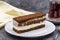 Portion tiramisu cake on dark background. Traditional world cuisine