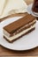 Portion tiramisu cake on wooden background. Traditional world cuisine delicacies.