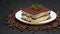 Portion of Traditional Italian Tiramisu dessert and coffee beans