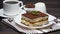 Portion of Traditional Italian Tiramisu dessert, cup of espresso, milk and coffee beans