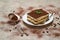 Portion of Traditional Italian Tiramisu dessert on grey concrete background