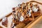 Portion of Viennese wafers with cream, chocolate, nuts, syrup and ice cream on wooden table