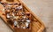 Portion of Viennese wafers with cream, chocolate, nuts, syrup and ice cream on wooden table