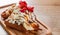 Portion of Viennese waffle with cream, strawberry, banana, caramel and ice cream on wooden table