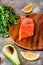 Portion of wild salmon fillet with aromatic herbs, spices, avocado and lemon- healthy breackfast, diet, omega 3 concept