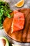 Portion of wild salmon fillet with aromatic herbs, spices, avocado and lemon- healthy breackfast, diet, omega 3 concept