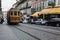 Porto, Portugal street featuring an old brown and tan trolley on ancient cobblestones with a row modern cars