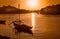 Porto at sunset: Duoro river with rabelo boat in front of setting sun and Arrabida bridge in background, Portugal