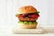 Portobello mushroom meatless burger on a marble serving board against a white wood background